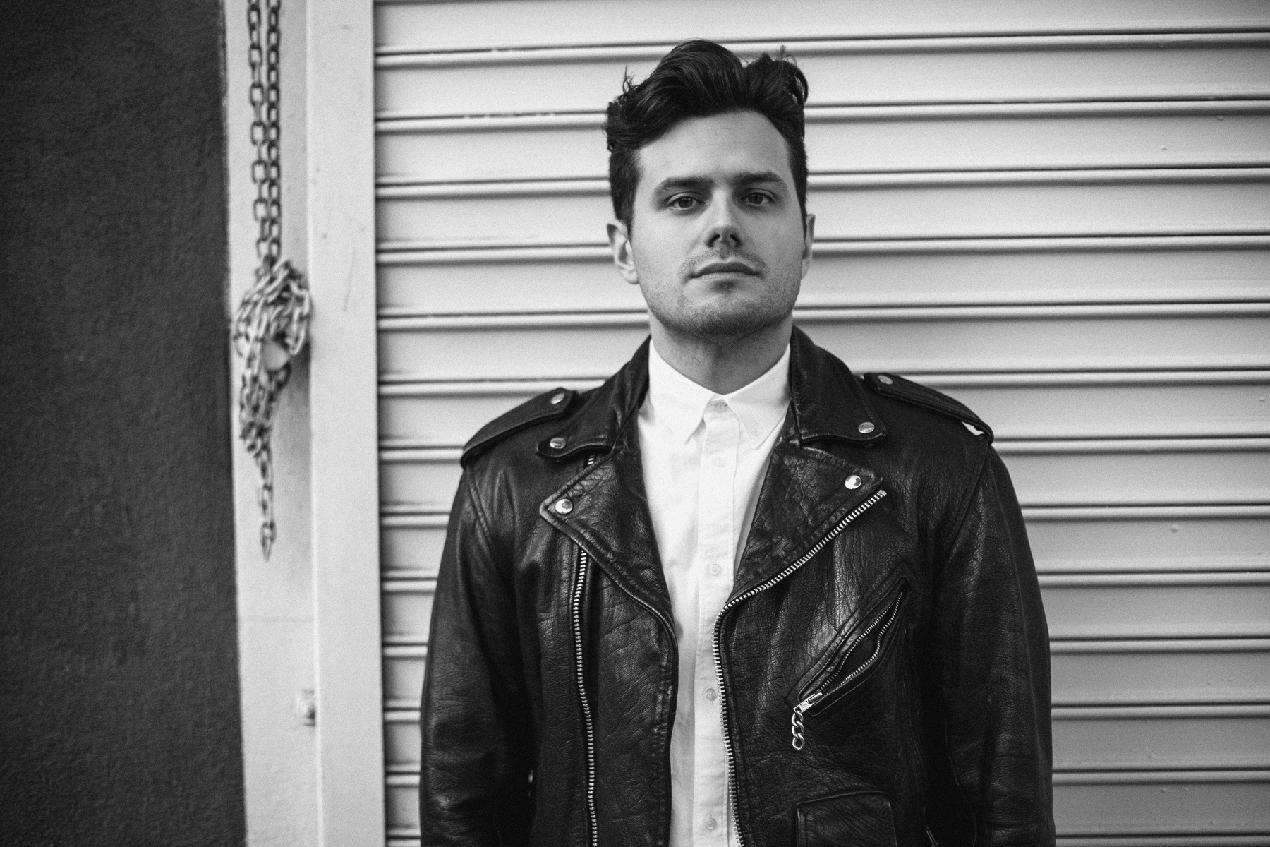 Black-and-white portrait of Elvis Suarez in a leather jacket